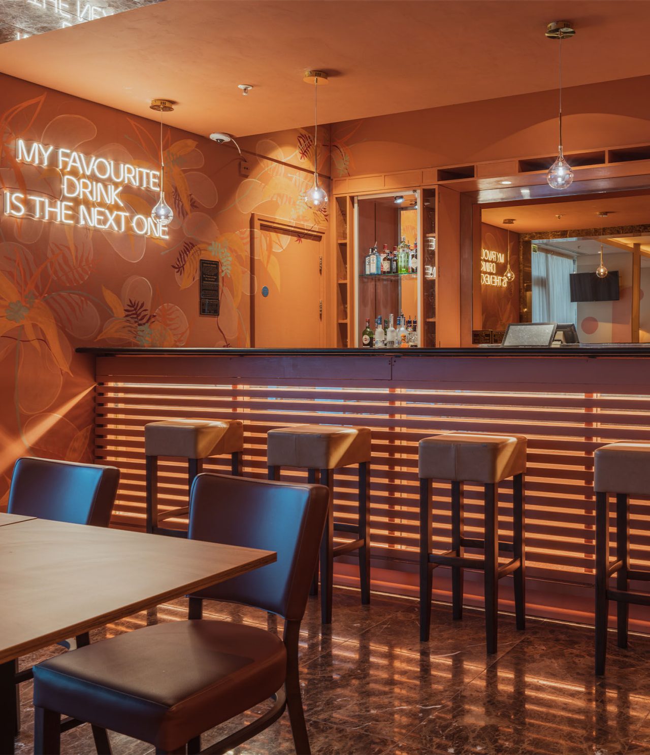 El bar The Bridge, del Hotel 4 Estrellas en Londres, tiene un mostrador con bancos altos y luz LED en la pared