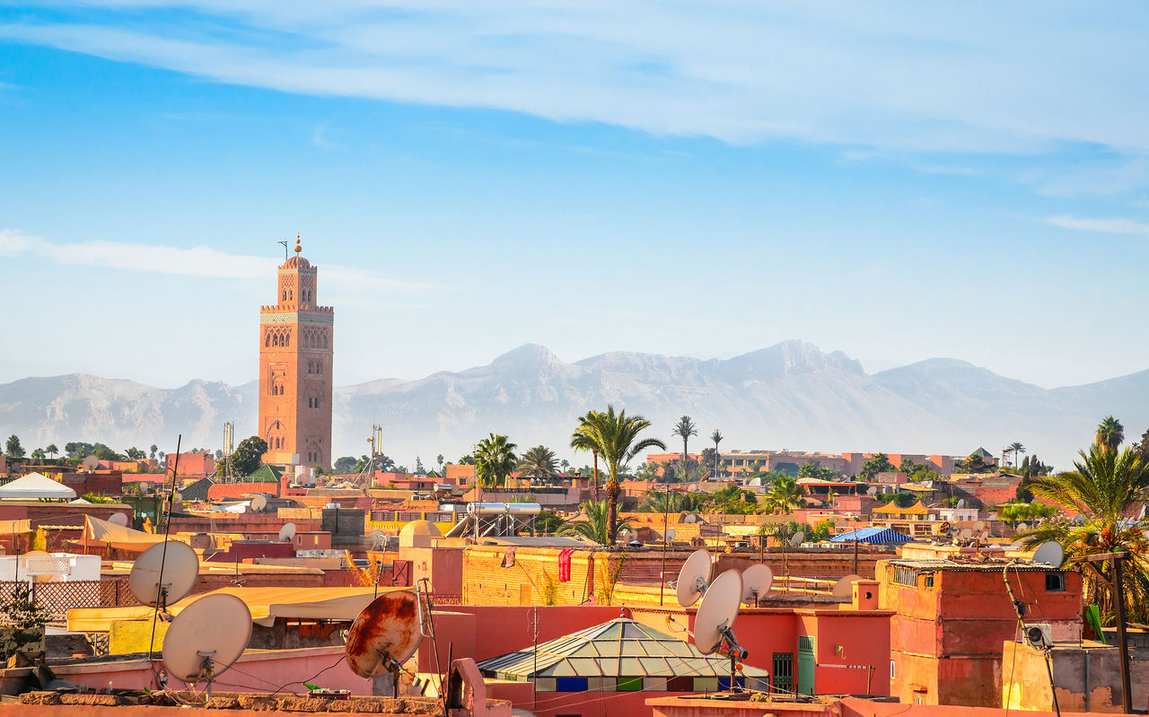 Vista de cima do centro histórico da cidade de Marraquexe, com a torre da Mesquita Cutubia e as montanhas em redor