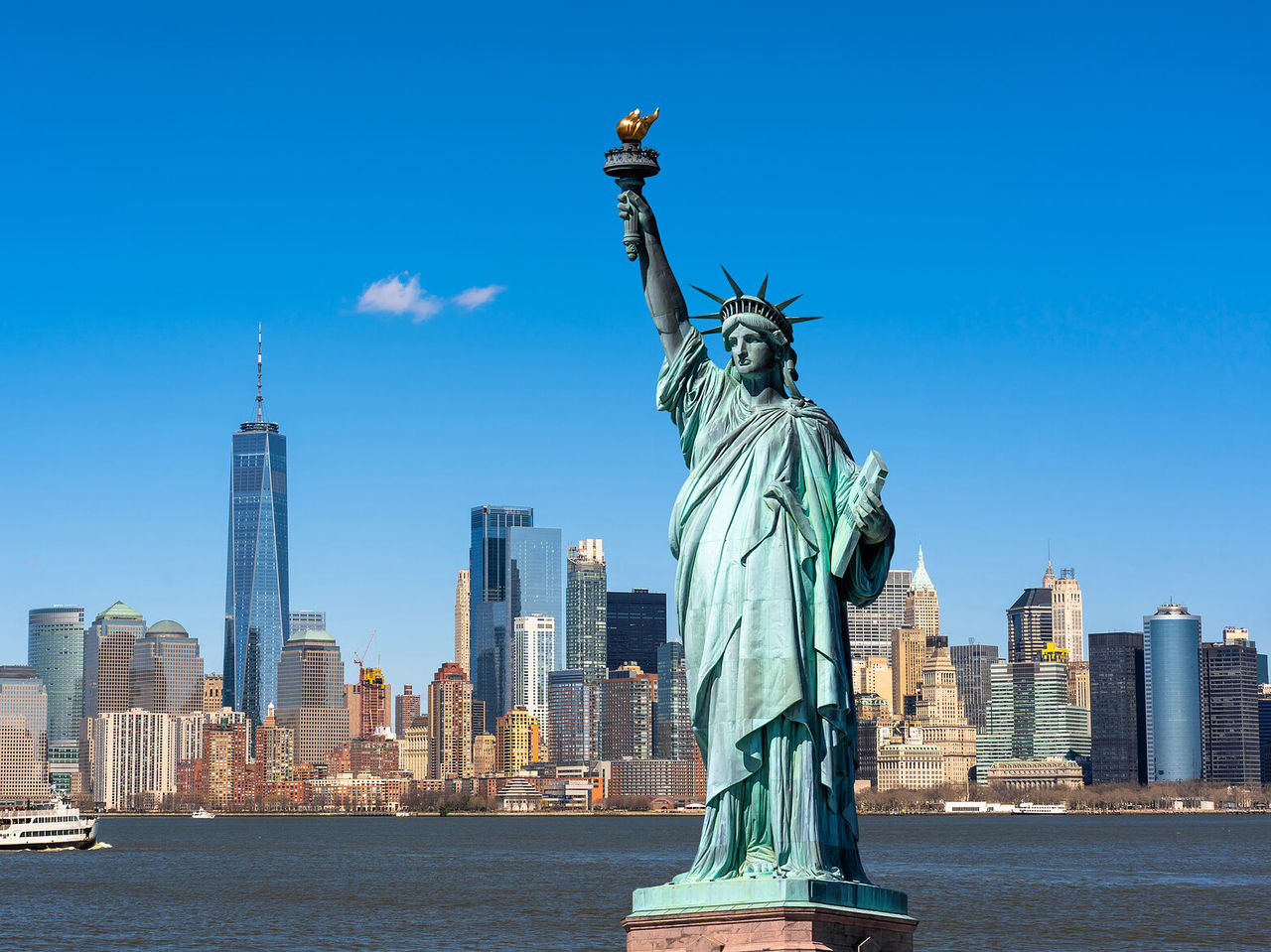 Paisagem urbana de Nova York com a Estátua da Liberdade em primeiro plano, e o horizonte de Nova Iorque como plano de fundo