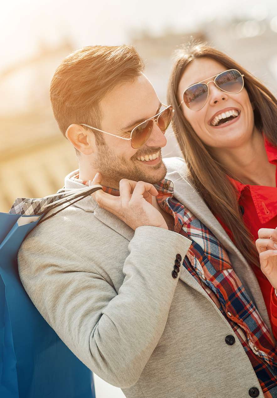 Casal sorridente a fazer compras na Rua Oscar Freire, uma rua de lojas de luxo e boutiques elegantes em São Paulo