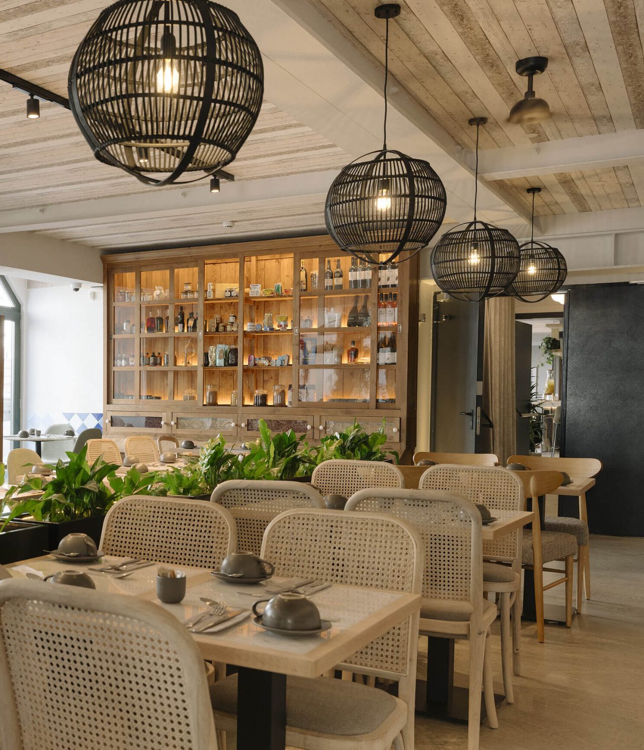 O restaurante Olive, do Hotel na Baixa de Lisboa tem várias mesas, plantas e decoração moderna