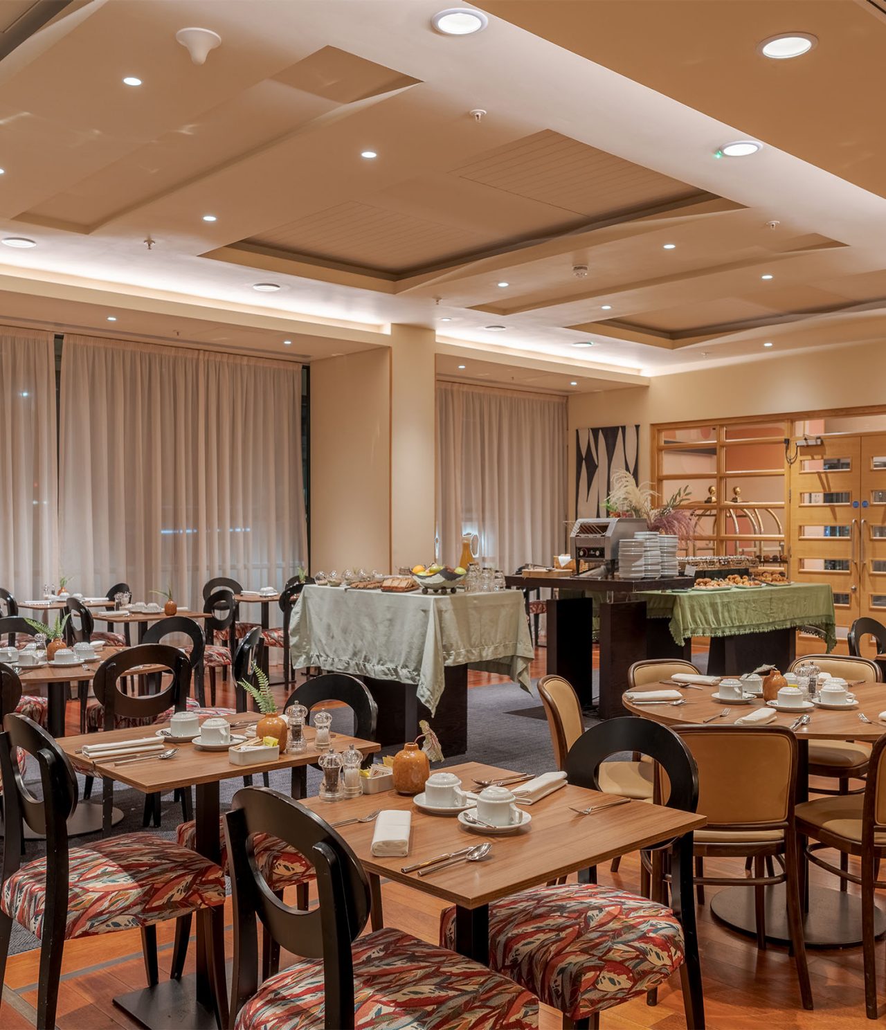 O restaurante Atlântico, do Hotel 4 Estrelas em Londres, tem uma mesa de buffet e mesas de refeição