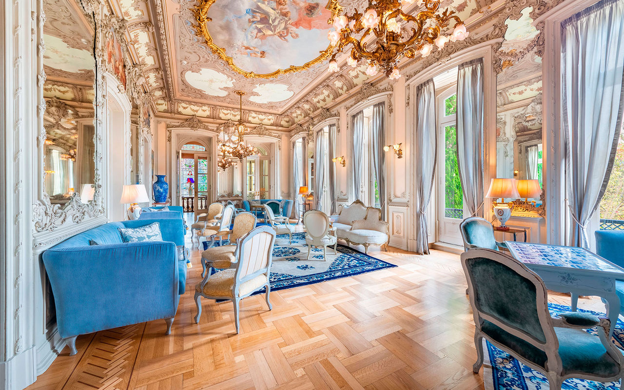 Sala com decoração histórica e teto detalhado num hotel de luxo em Portugal, que pertence à marca Pestana Collection