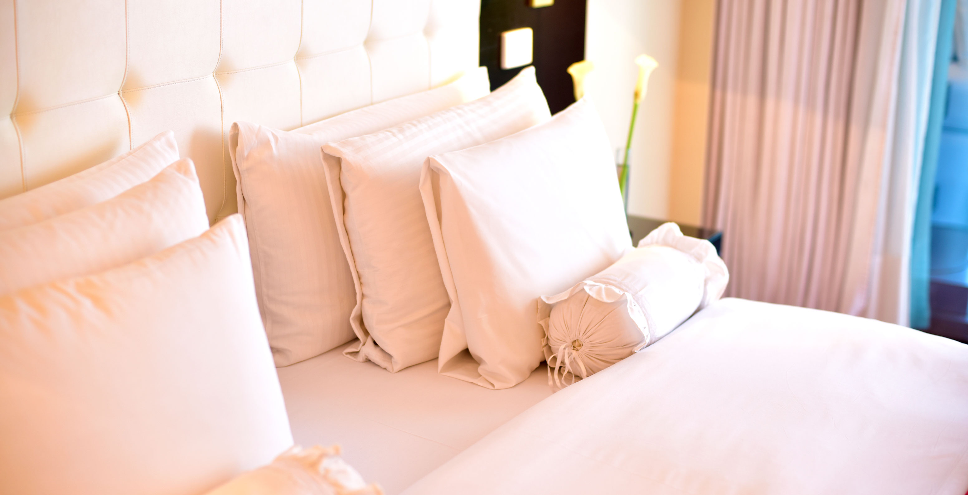 The Queen Standard at Pestana Buenos Aires has a double bed with various types of pillows