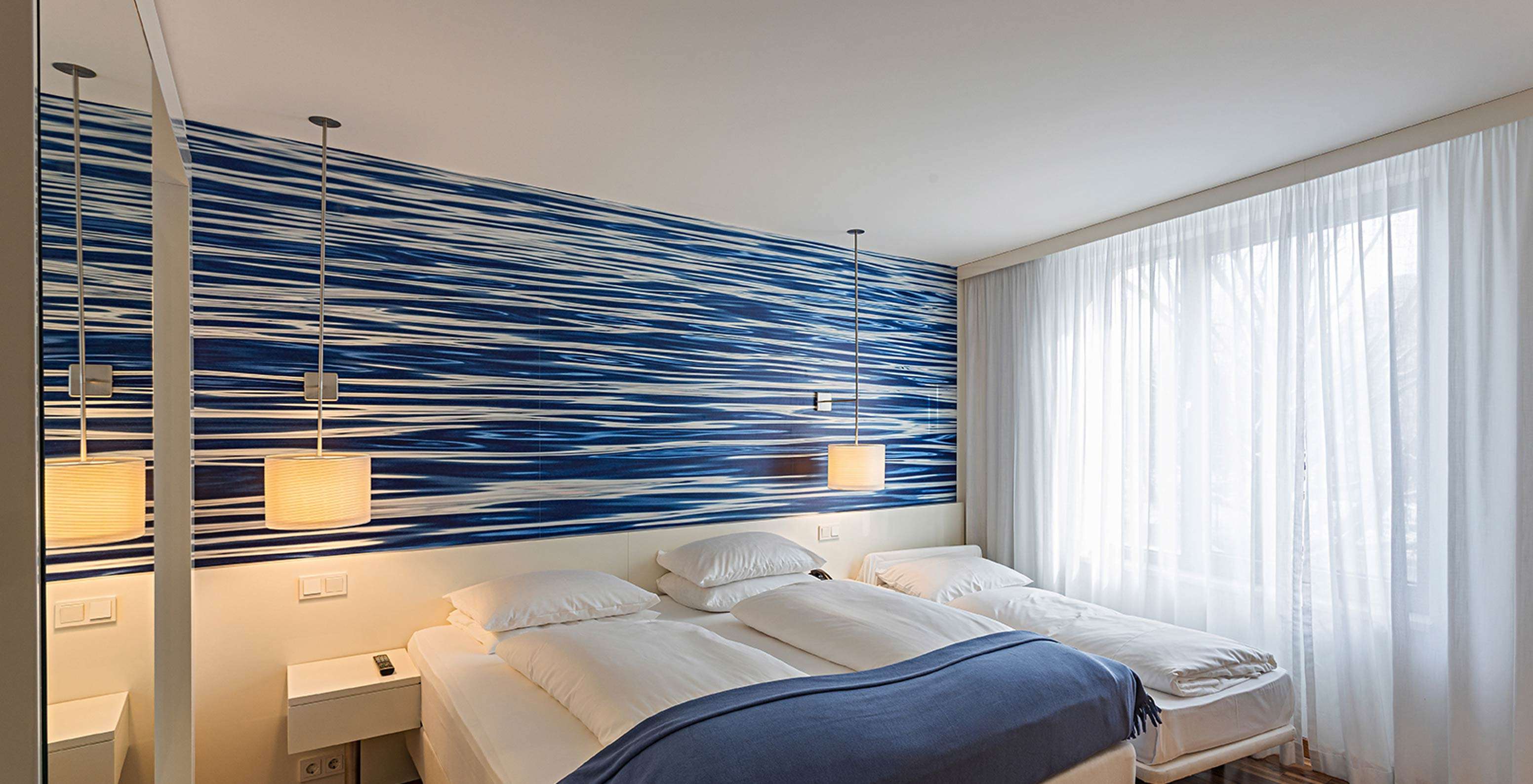 Family Deluxe with double or twin beds and blue-toned wallpaper.