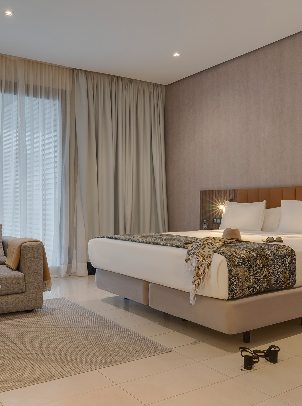 The Junior Suite at Pestana Casablanca has a spacious bedroom with a double bed and sofa with a balcony