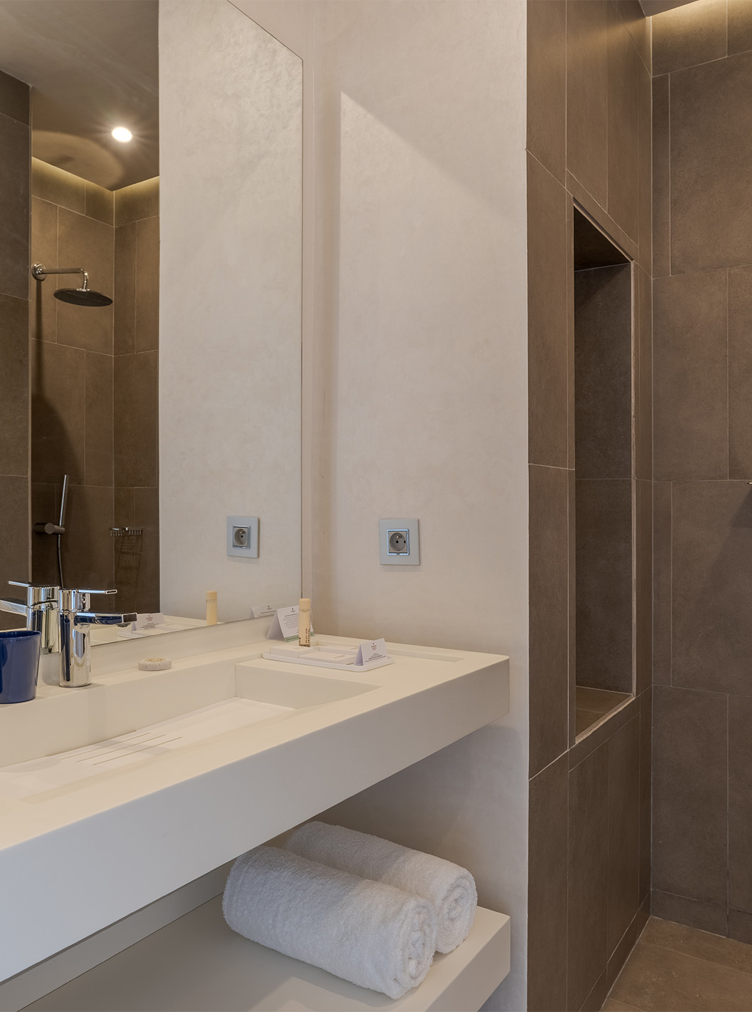 The CR7 Suite Avenue at Pestana CR7 Marrakech has a bathroom with a walk-in shower and a sink with a large mirror