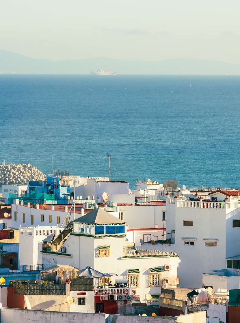 View of the city of Tangier, Morocco, with white buildings of traditional Moroccan architecture and the sea in the background