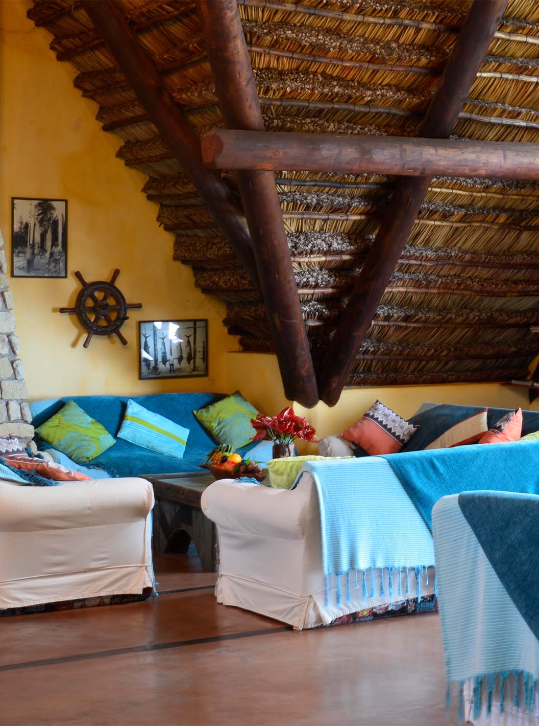 Bungalow Suite T2 at Pestana Bazaruto Lodge has a spacious room with sofas covered with blue blankets and colorful cushions