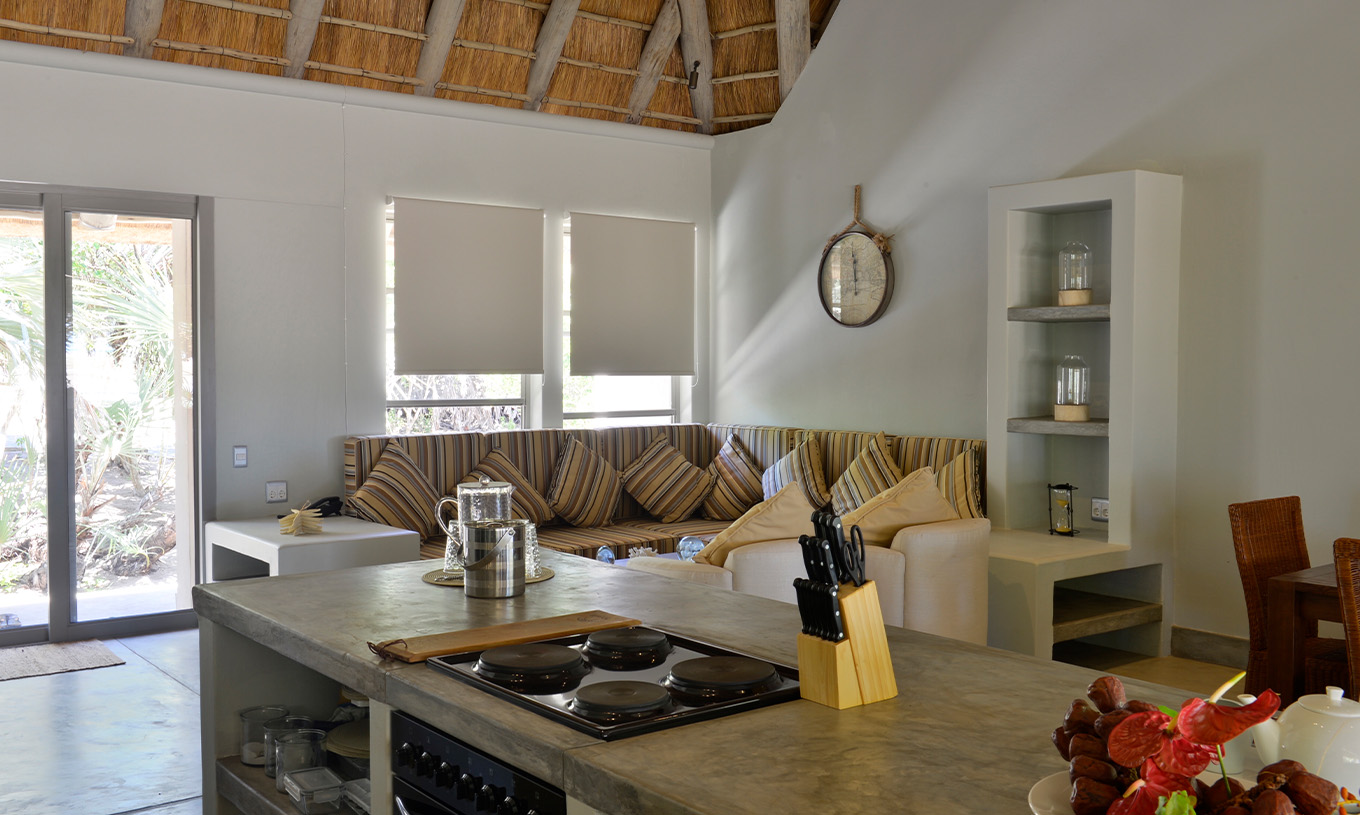 As Villas T2 do Pestana Bazaruto Lodge tem uma sala com sofás e mesa de refeição e com a cozinha em open space