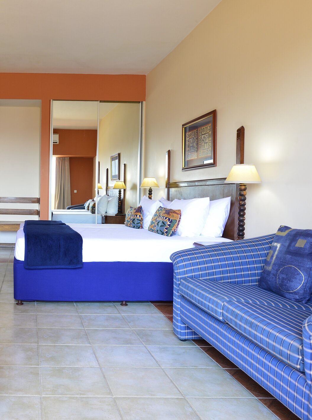 The Family Executive Suite of Pestana Rovuma has a double bed, wardrobe with mirror, television, and a sofa