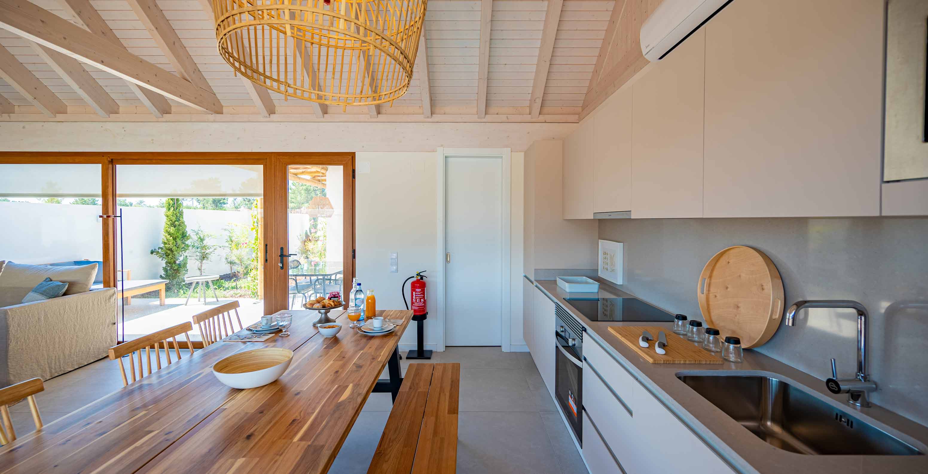 The Standard Villa T1 at Pestana Comporta Village Residences has a modern kitchen with a wooden table and an oven