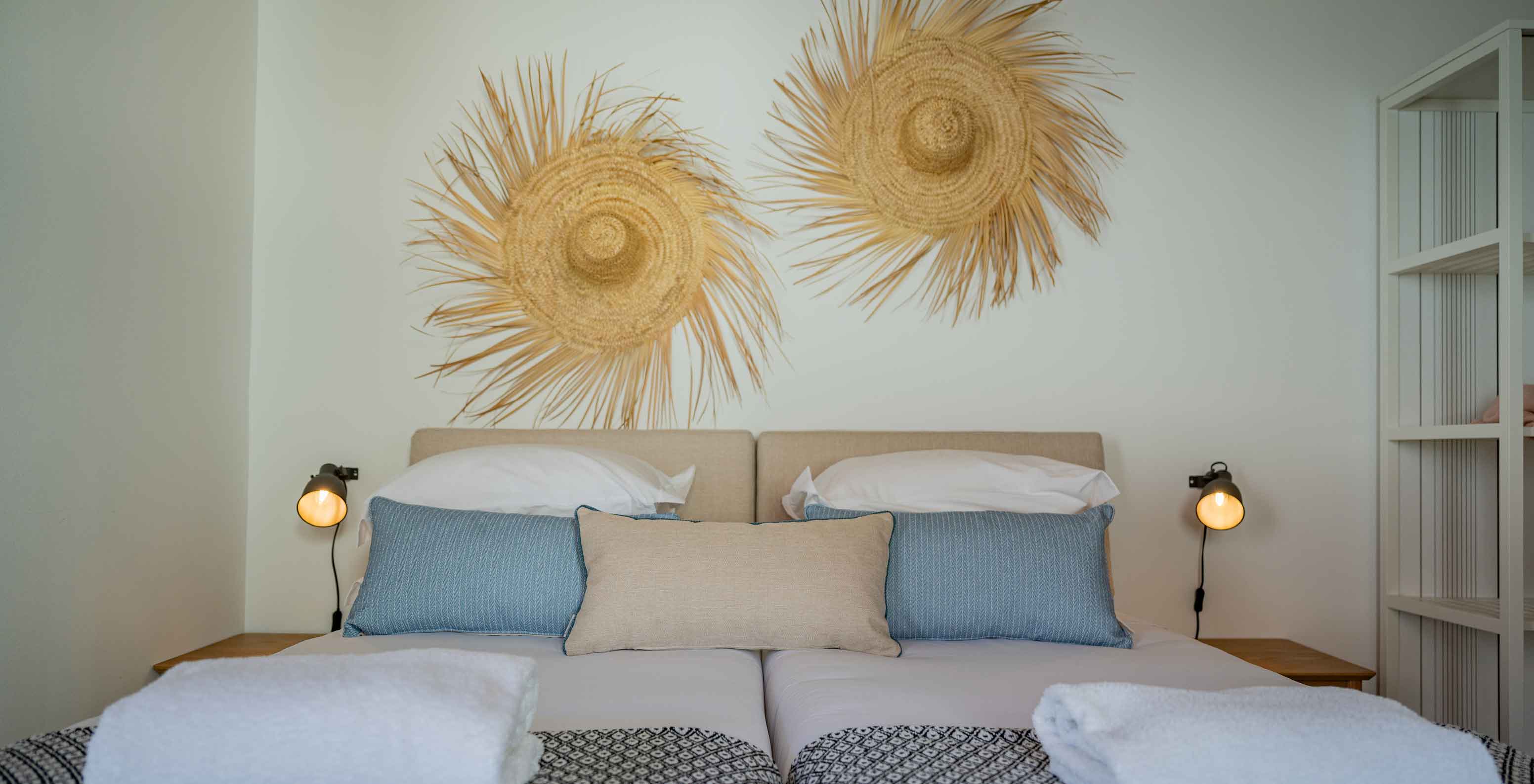 The Standard Villa T2 at Pestana Comporta Village Residences has a double bed with straw decoration on the wall