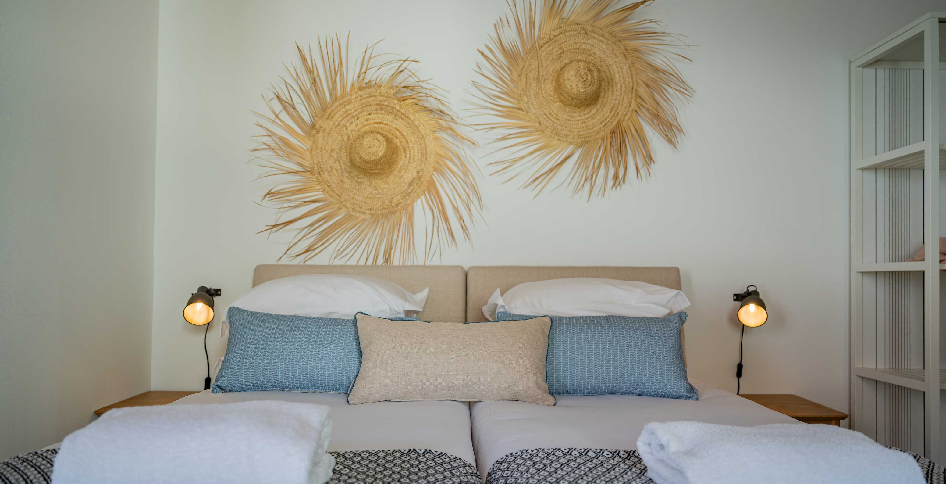 The Standard Villa at Pestana Comporta Village Residences has a double bed with straw decoration on the wall