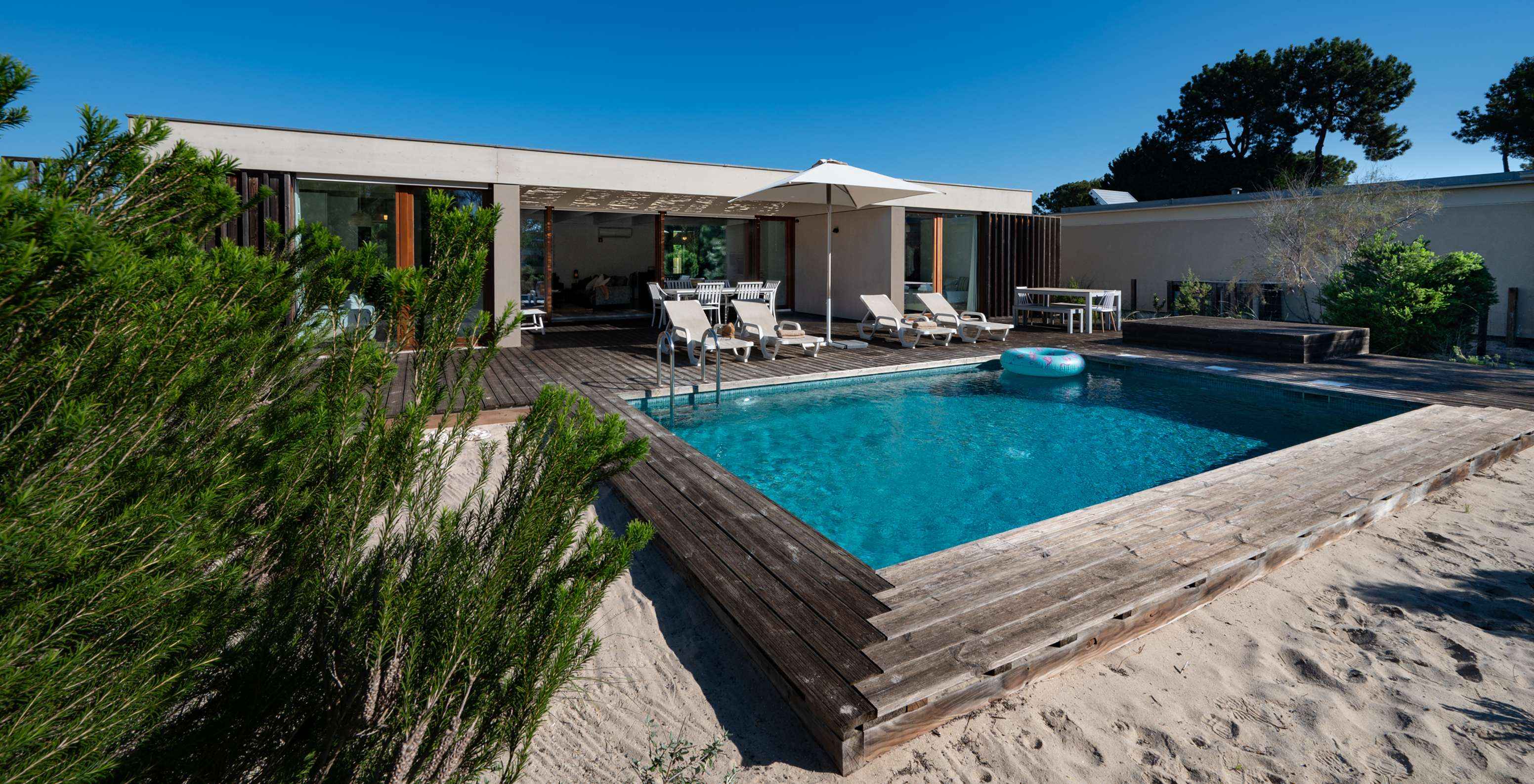 The Beach Villa with Private Pool of Pestana Tróia Eco Resort has several sun loungers, a sun umbrella, and a float