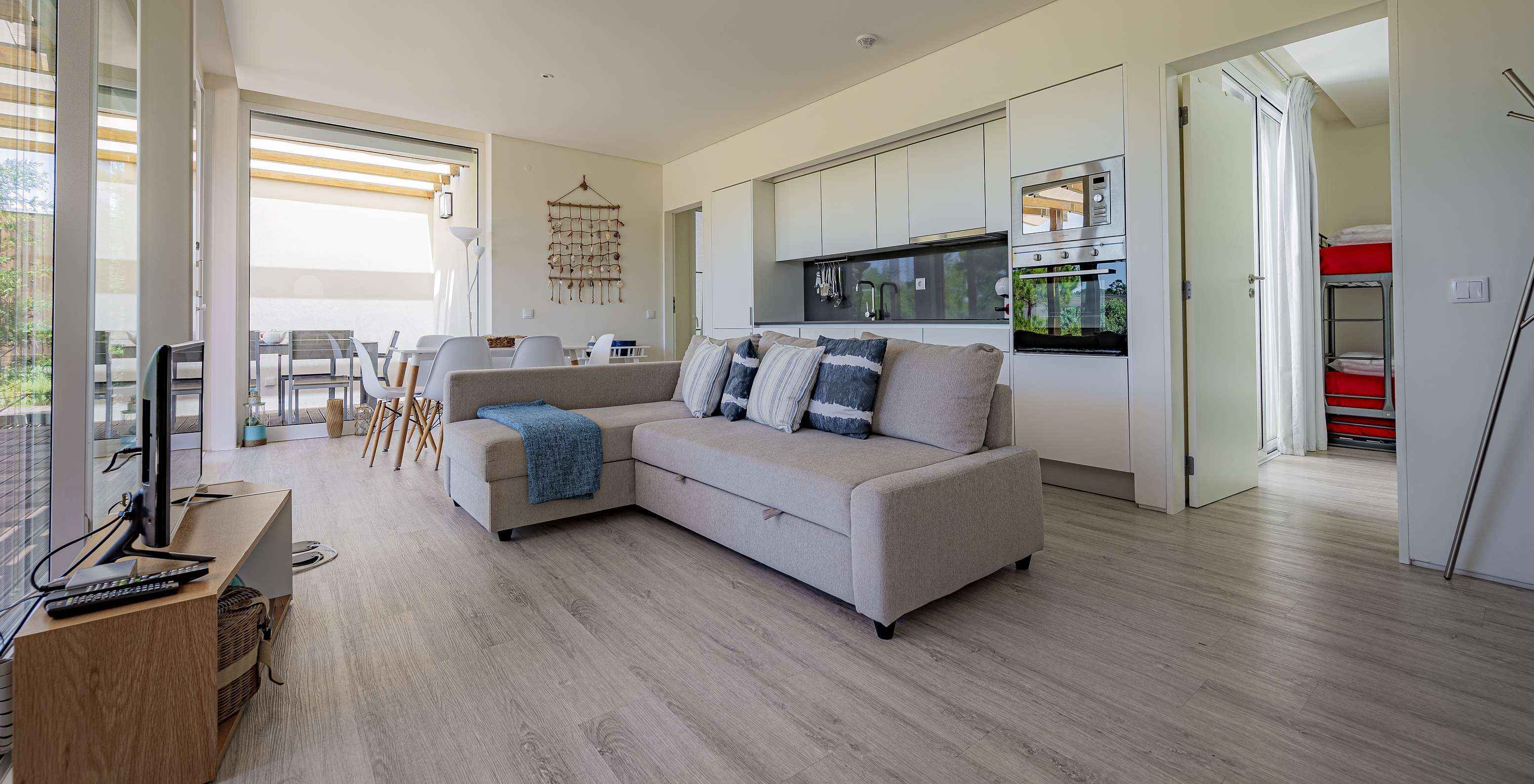 The Green Villa of Pestana Tróia Eco Resort has a room combined with the kitchen, with sofa, dining table, and television