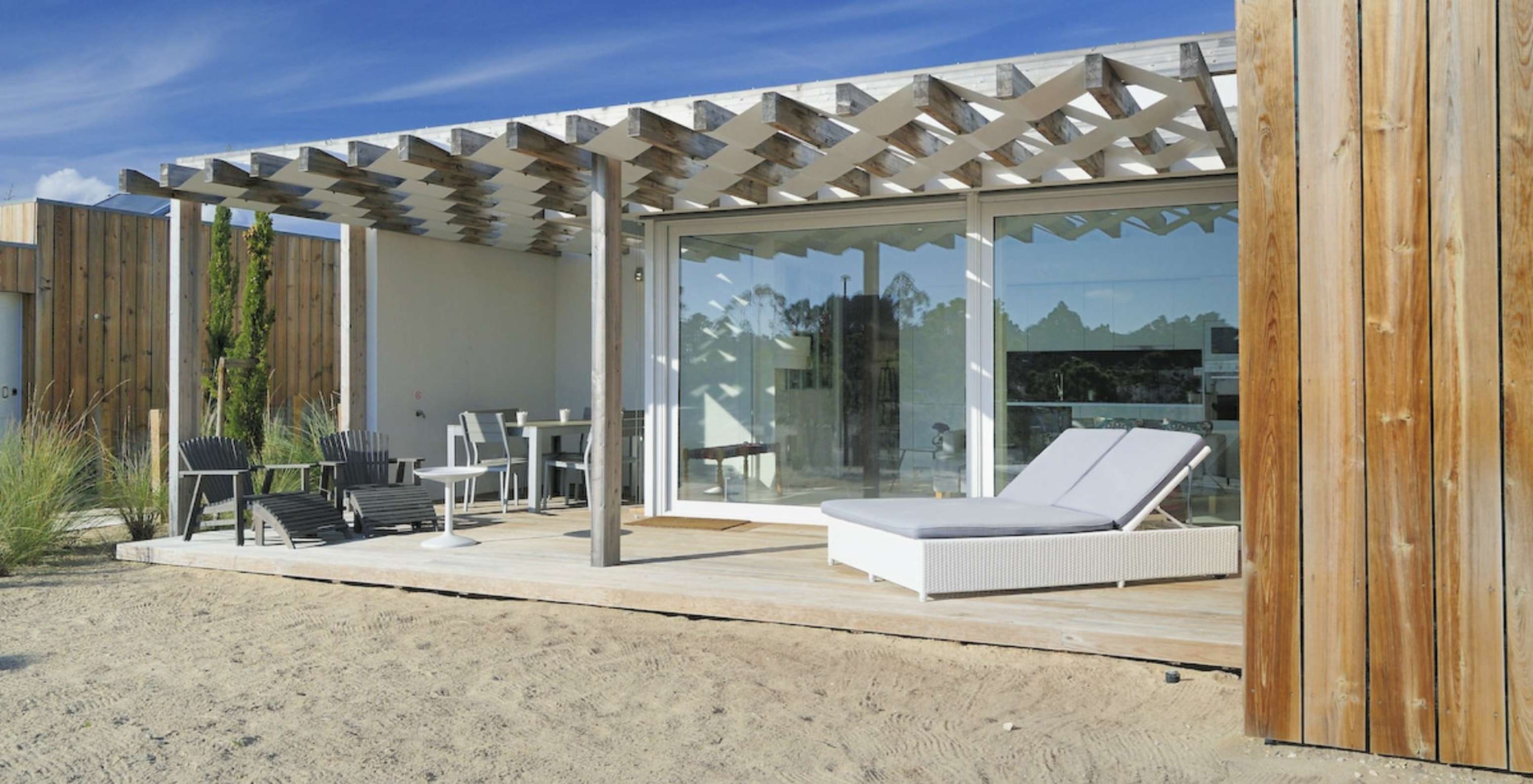 The Green T3 Villa of Pestana Tróia Eco Resort has a terrace with sun loungers, table, and chairs