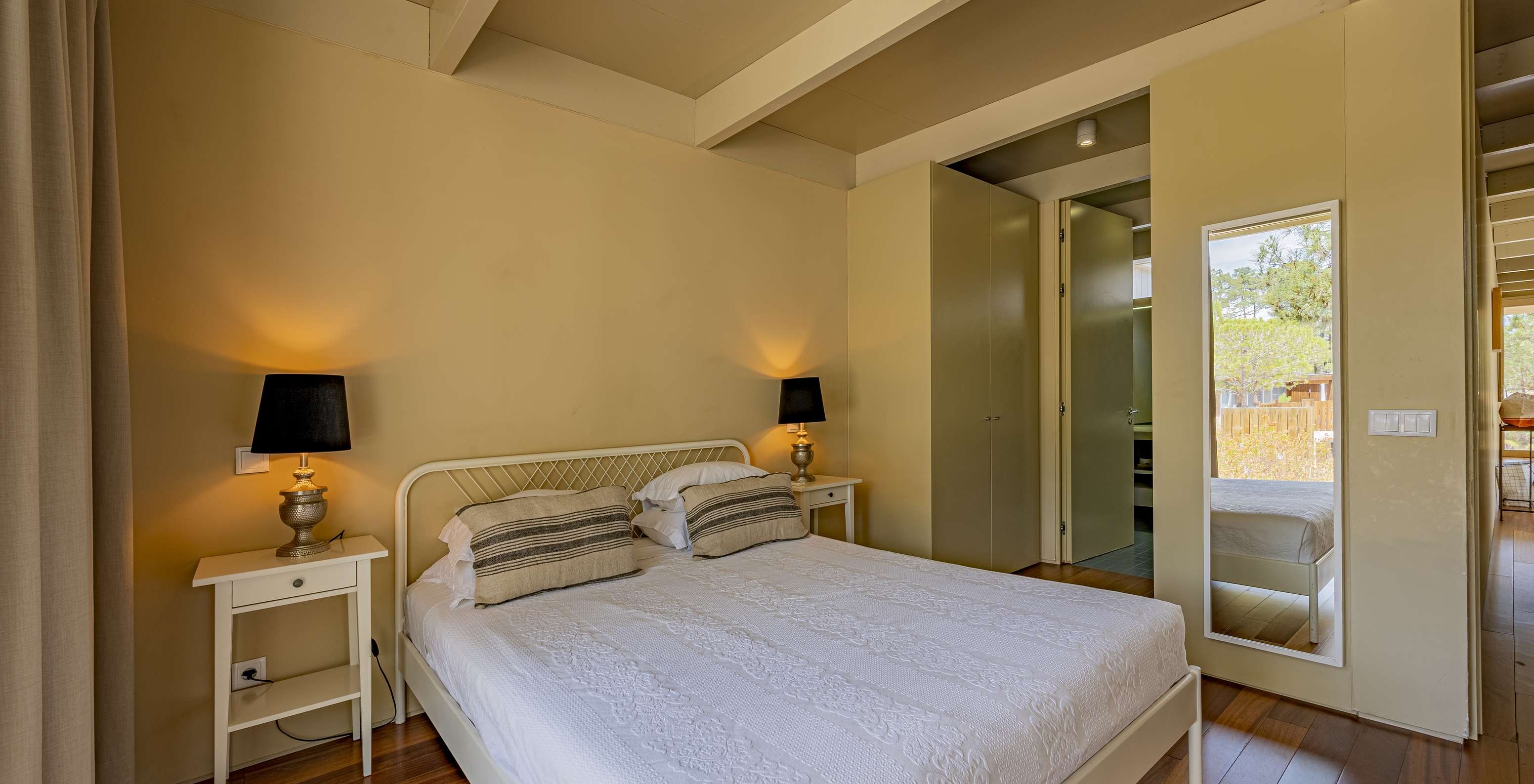 The Townhouse of Pestana Tróia Eco Resort has a double bed, two bedside tables, and a mirror on the wall