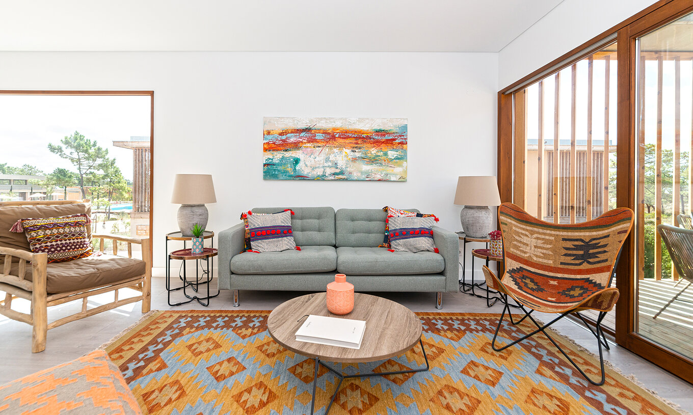 The Eco Village Apartment 1st Floor of Pestana Tróia Eco Resort has a sofa, several chairs, a rug, and a side table