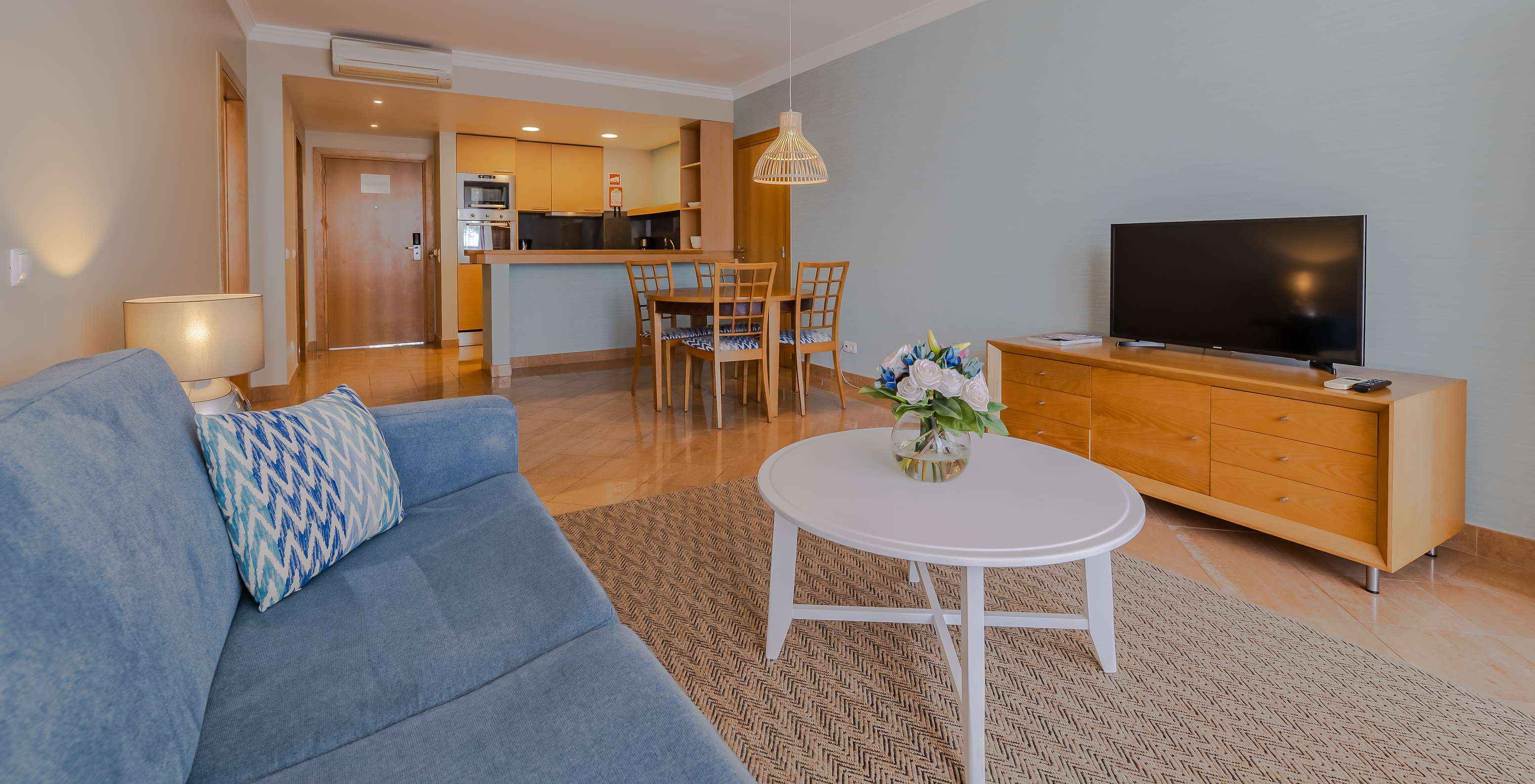 The 1 Bedroom Apartment at Pestana Alvor Park has a living room with a sofa, dining table, and kitchenette
