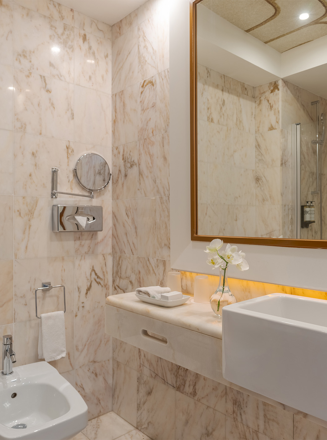The Garden View Suite at Pestana Alvor Praia has a marble bathroom with bidet, sink, and flower vase