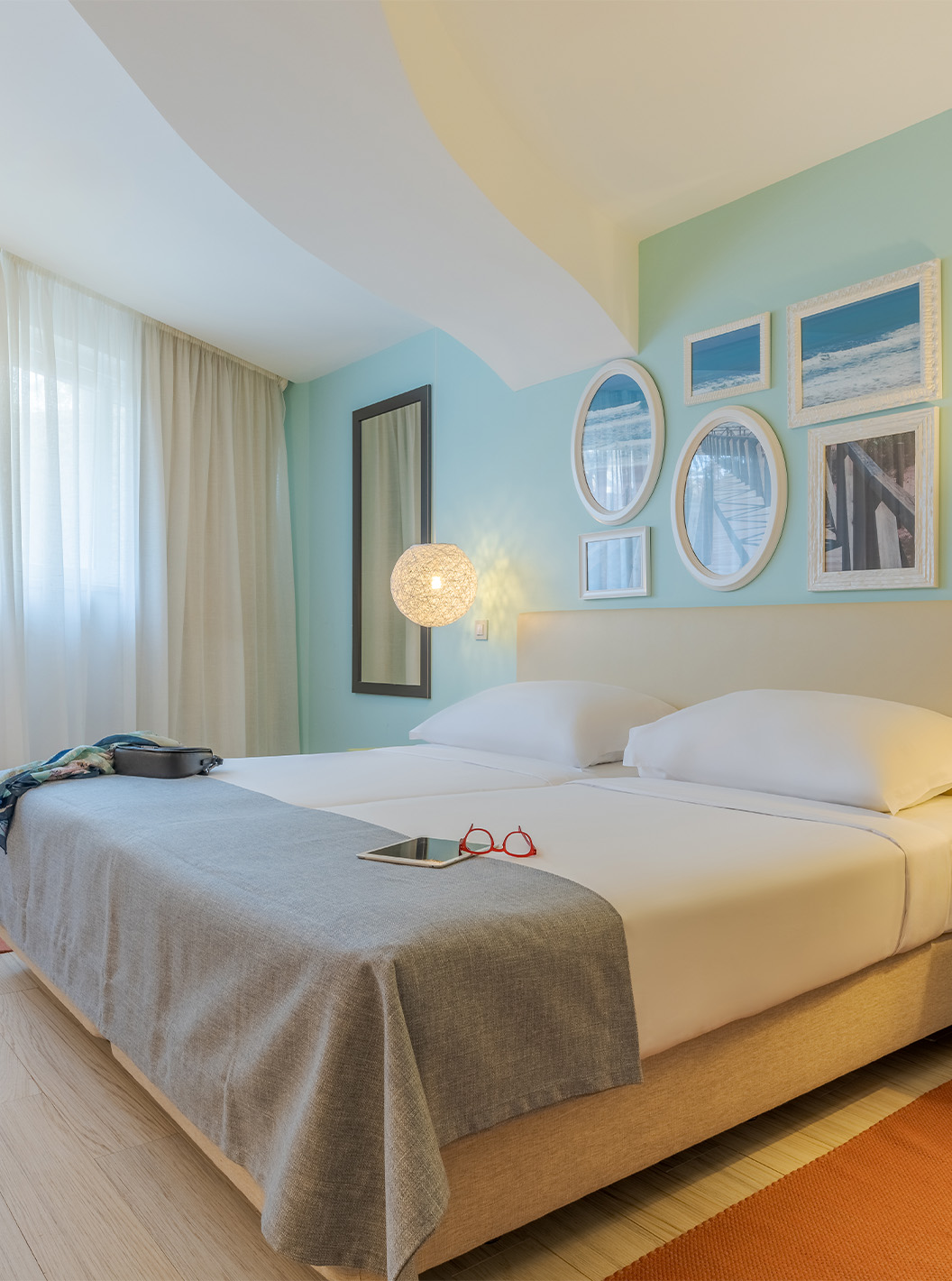 The Garden View Suite T1 at Pestana Alvor Praia has two joined beds, a bedside table with lamp, rug, and art