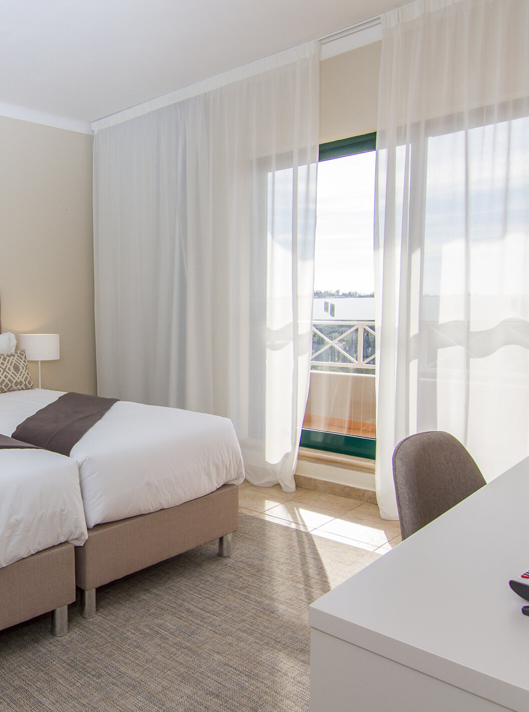 The T2 Apartment at Pestana Gramacho Residences has two single beds, air conditioning, and a window with a balcony