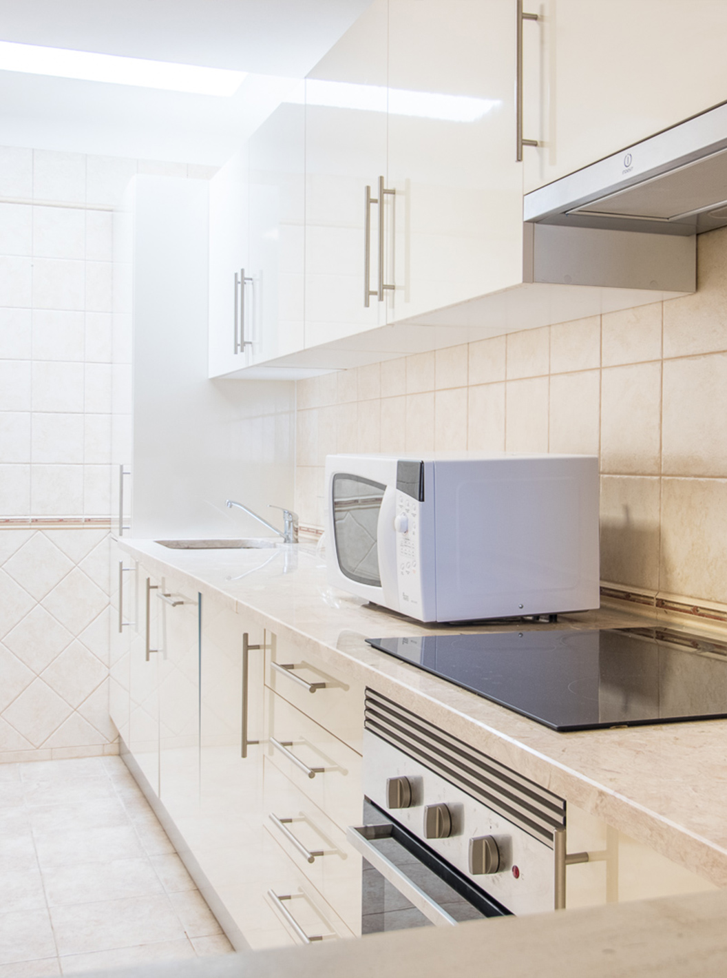 The two-bedroom apartment at Pestana Gramacho has a simple kitchen with appliances and neutral decor