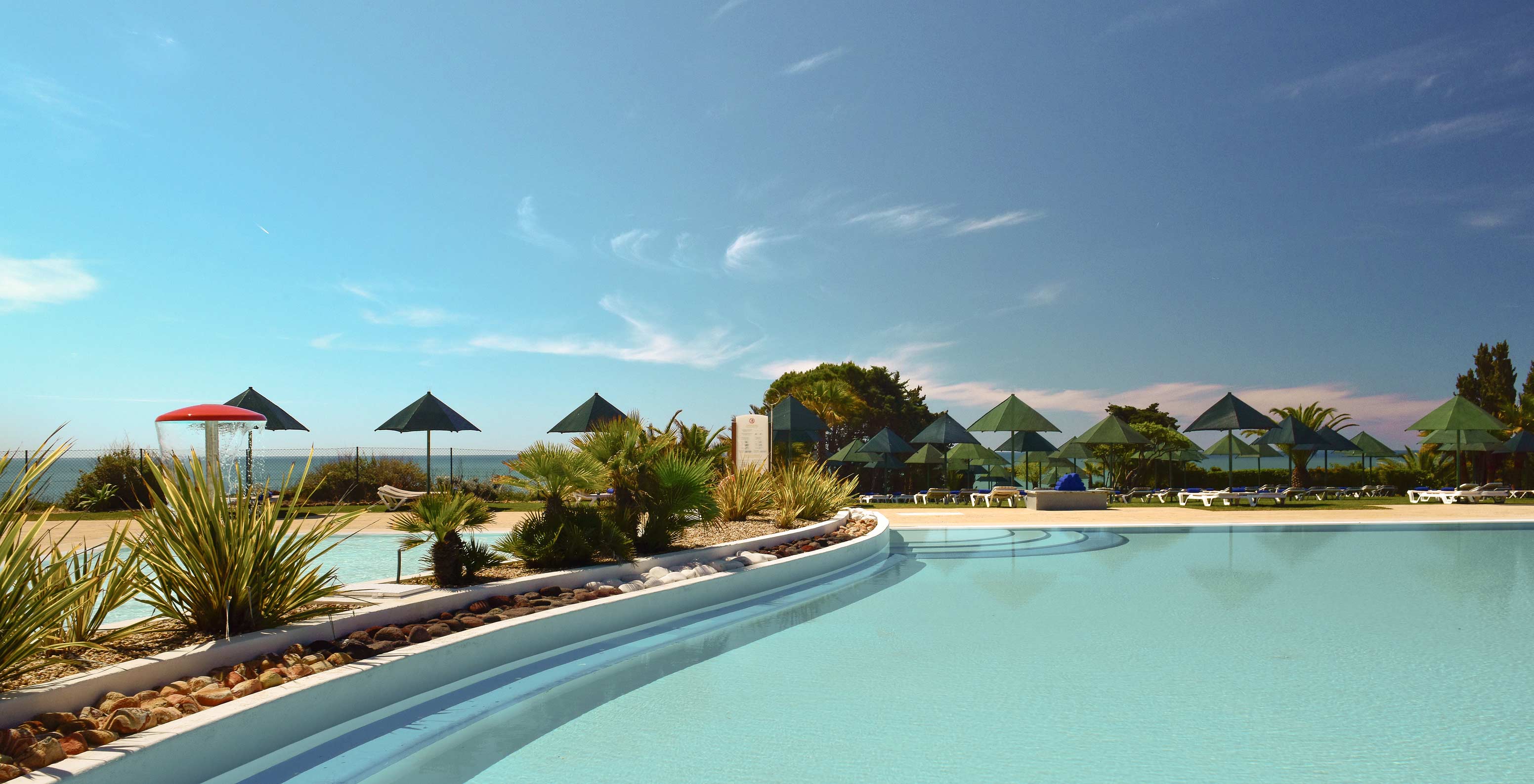 Outdoor pool at Pestana Viking, surrounded by greenery, with sun loungers and sea view