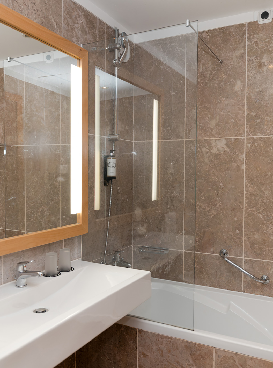 The Deluxe Side Sea View at Pestana Viking has a bathroom with sink, large mirror and bathtub with shower