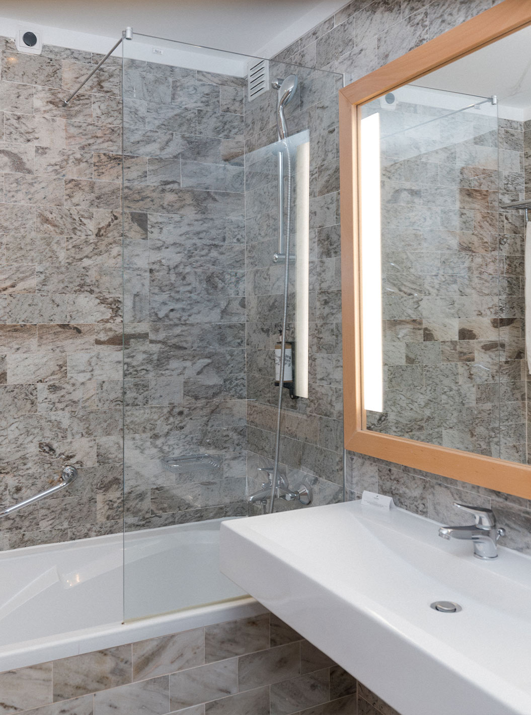 The Superior Sea View Suite at Pestana Viking has a bathroom with sink, large mirror and bathtub with shower