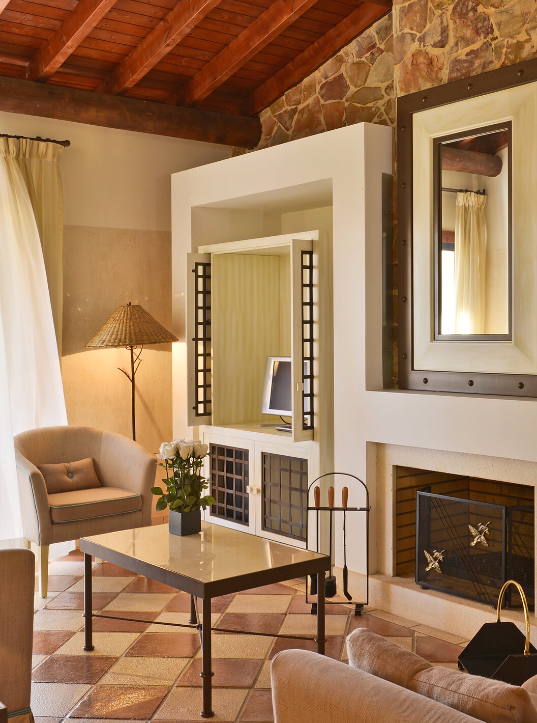 The Garden View Suite at Pestana Vila Sol - Vilamoura has a living room with sofas, a coffee table, a fireplace, and a window