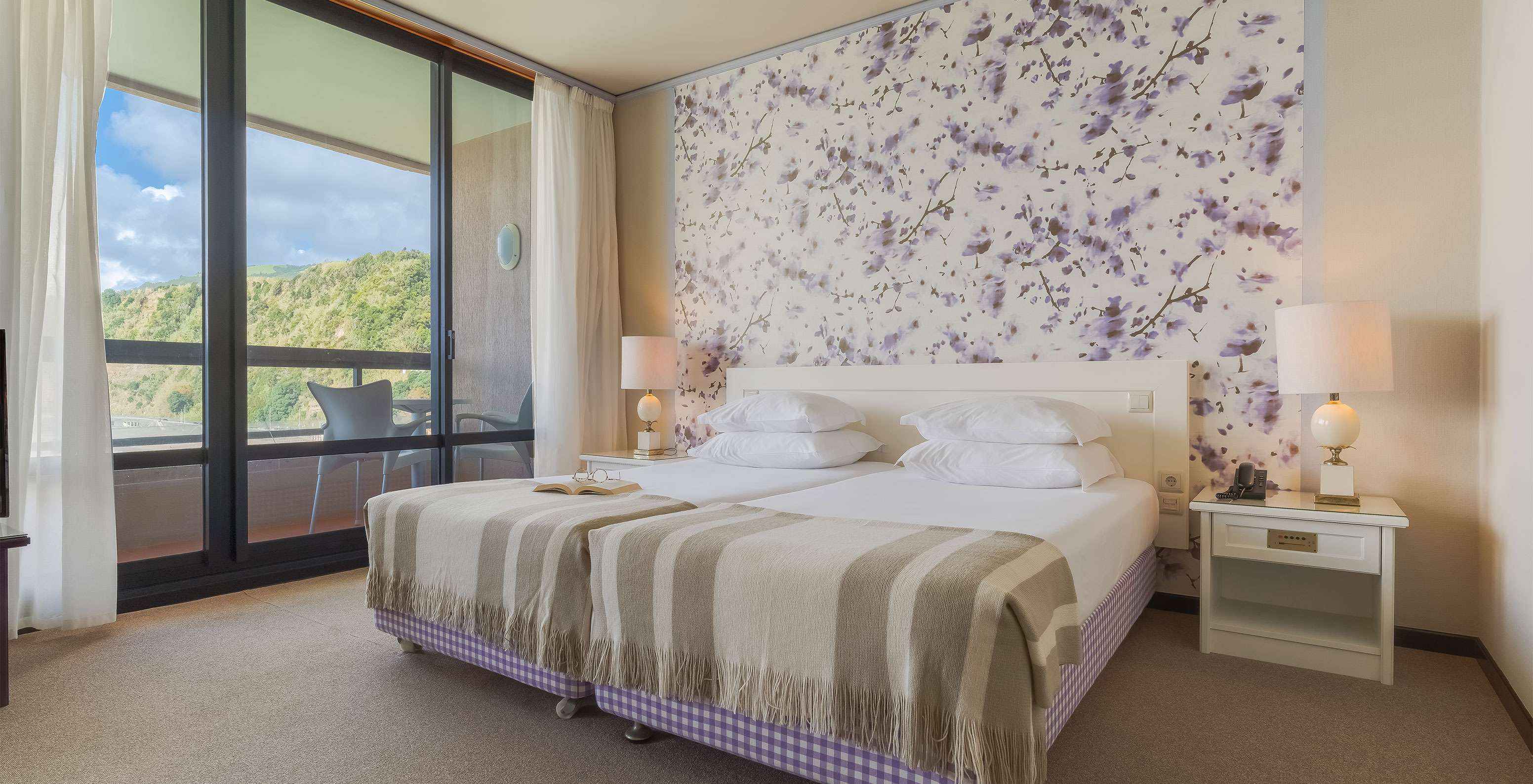 Junior Sea View Suite at Pestana Bahia Praia has a spacious area with two single beds, a sofa and a chair