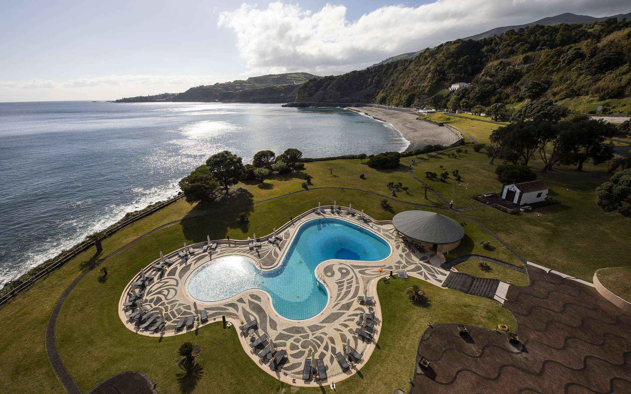 Pool with sea and beach view at Pestana Bahia Praia in São Miguel on a partly cloudy day