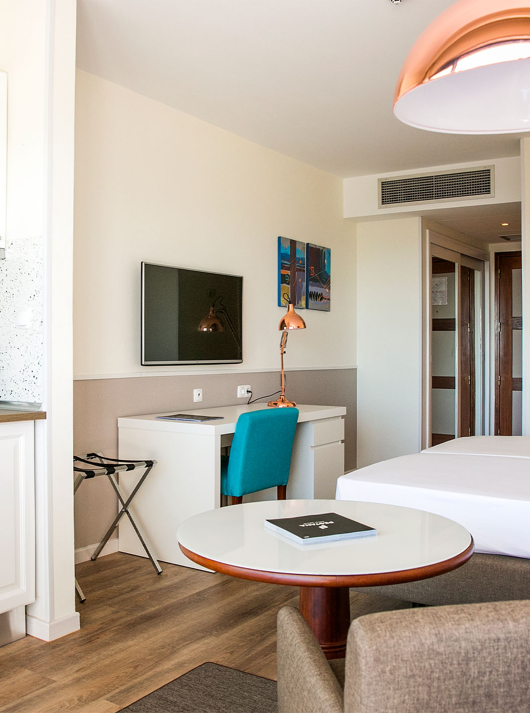 The Deluxe room at Pestana Cascais has two single beds, a TV, a desk, and a kitchenette