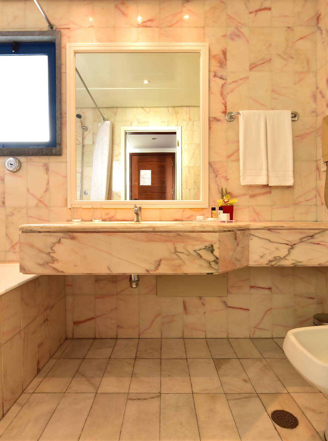 The Deluxe room at Pestana Cascais has a bathroom with a mirror, sink, and bathtub