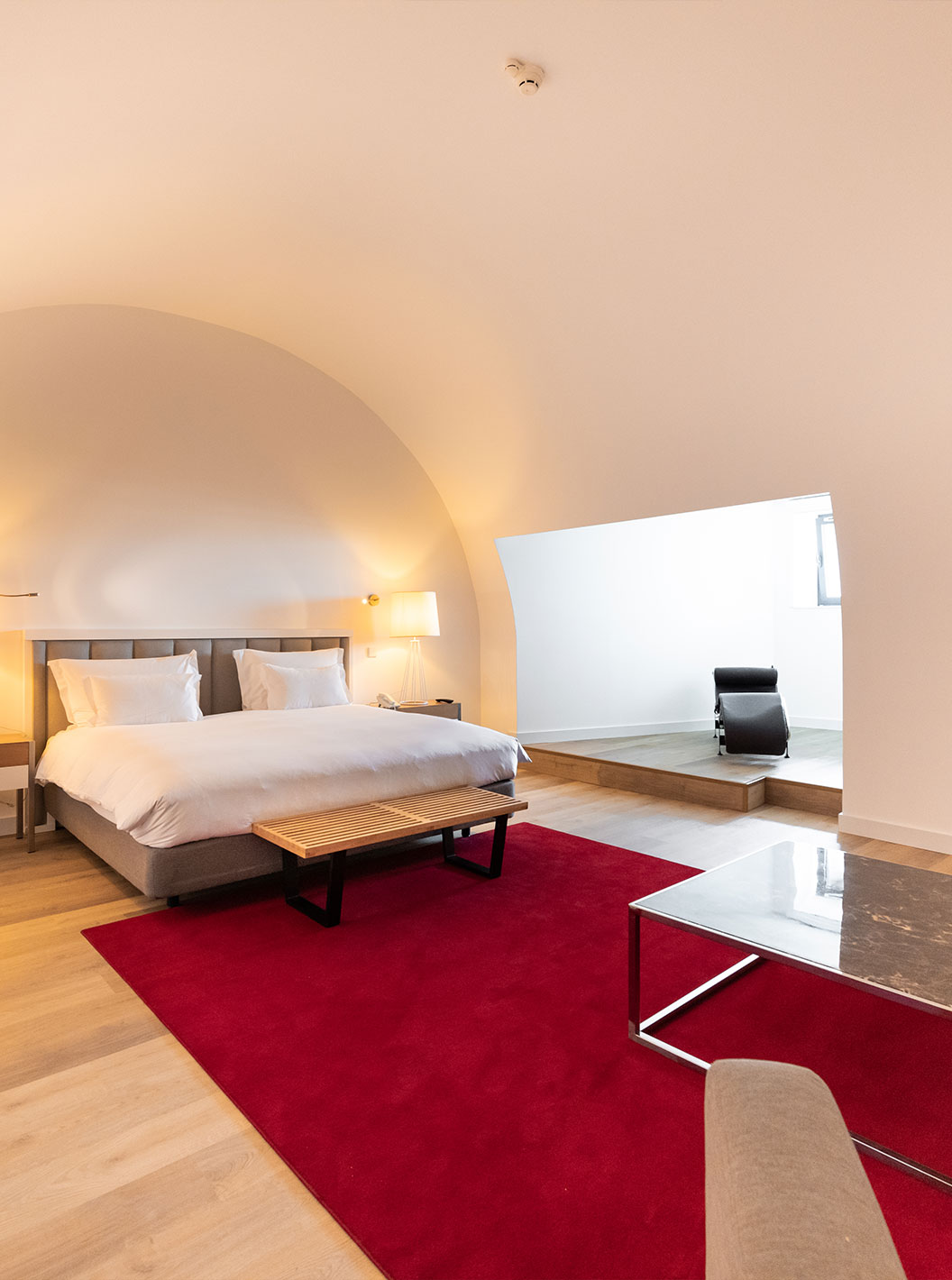 The Junior Family Suite at Pestana Cidadela Cascais is spacious with a high ceiling, a double bed, and a desk