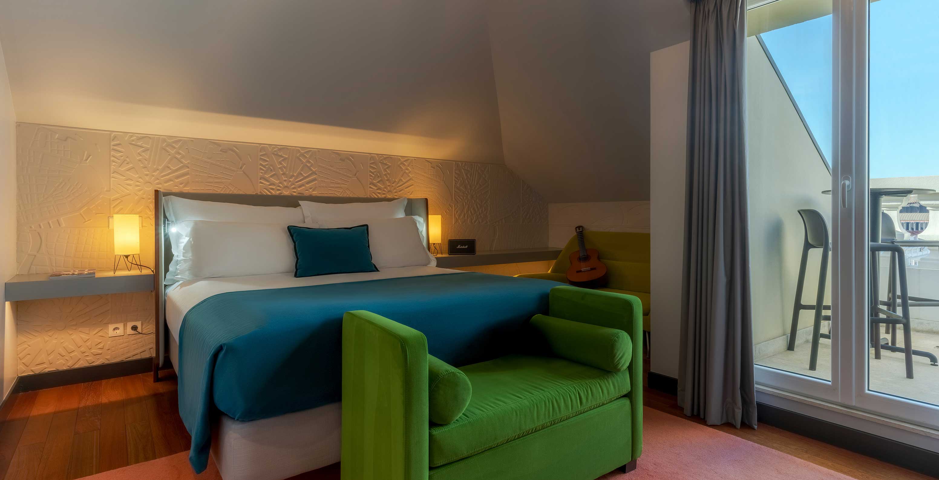 The CR7 Suite has a double bed a bench at the foot of the bed and a balcony at Pestana CR7 Lisboa