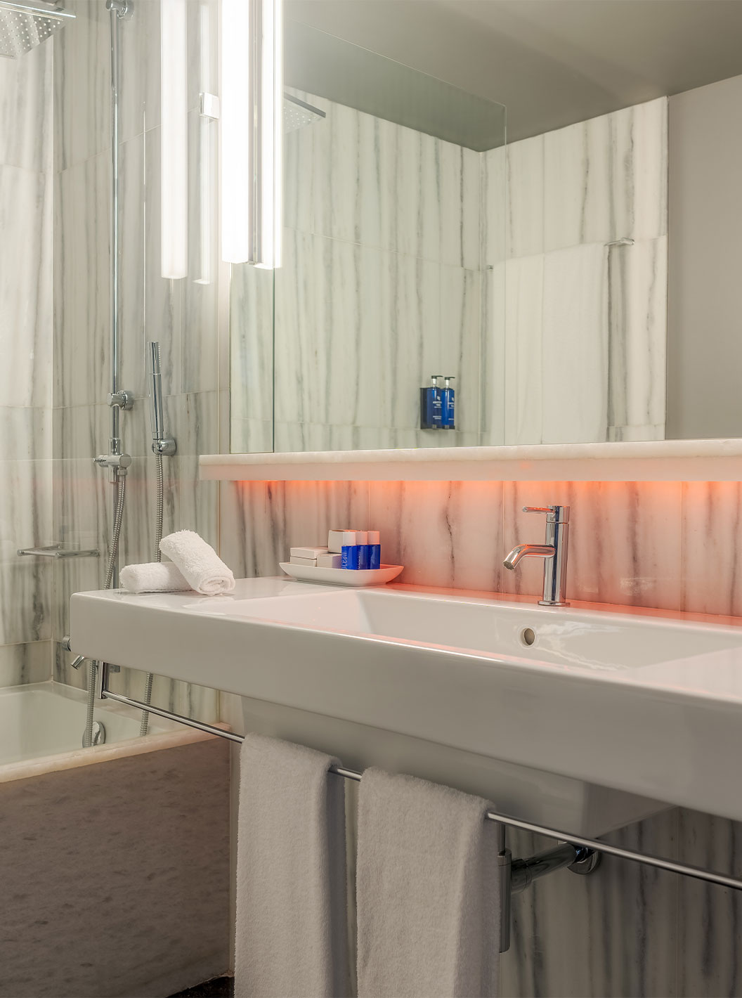 The CR7 Superior Corner Room at Pestana CR7 Lisboa features a bathroom with mirror, sink, and bathtub with shower