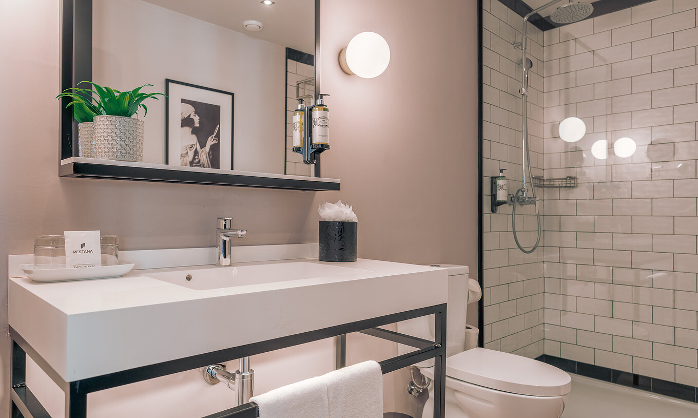 The Junior Suite at Pestana Lisboa Vintage has a bathroom with shower with glass doors with black details and a toilet