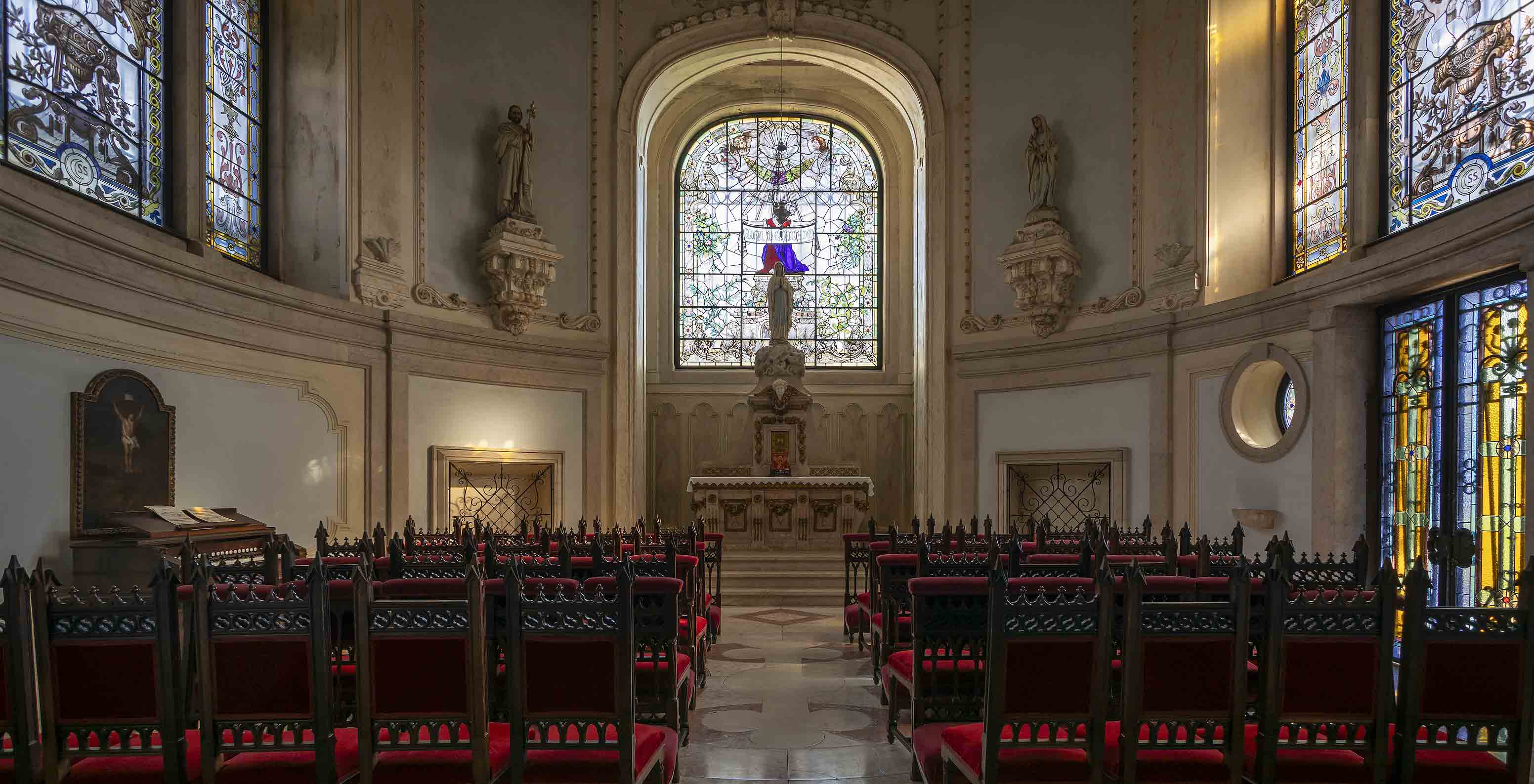 Pestana Palace Lisboa has a chapel with a small altar, several stained glass windows, and dark wooden chairs