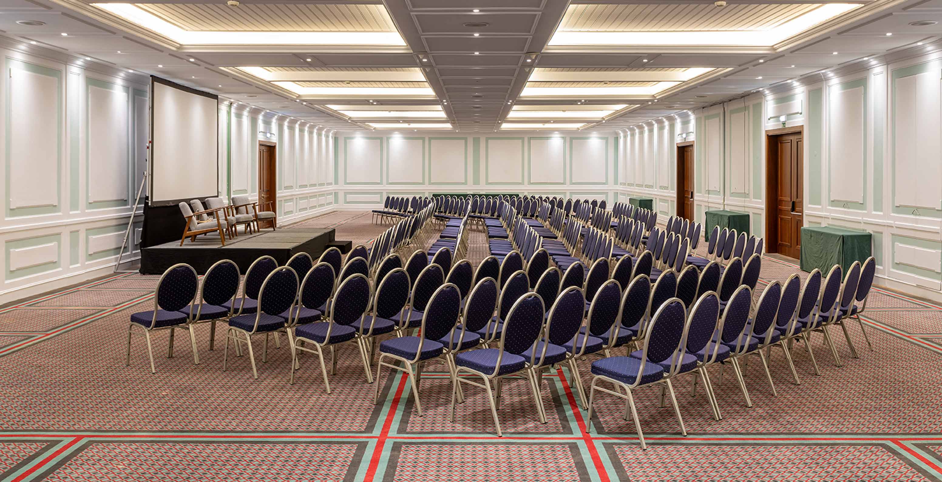 Pestana Palace Lisboa has a large carpeted meeting and event room with blue chairs