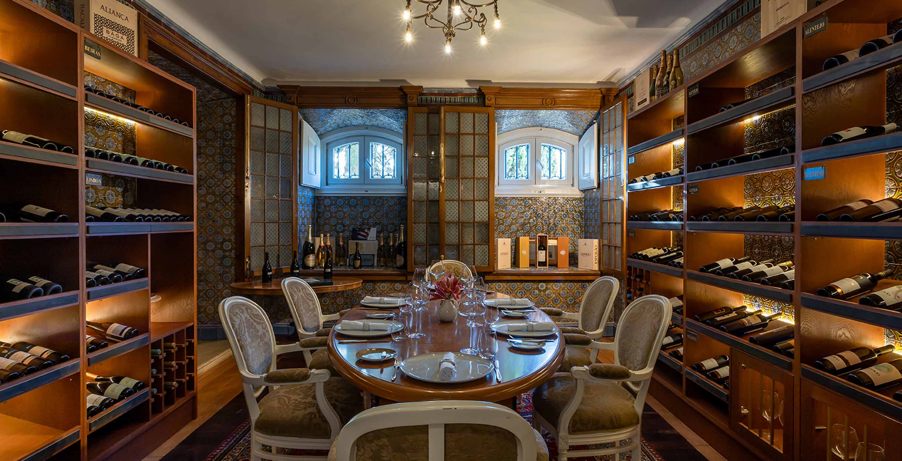 Pestana Palace Lisboa has a meeting room with an oval table and shelves with wine bottles