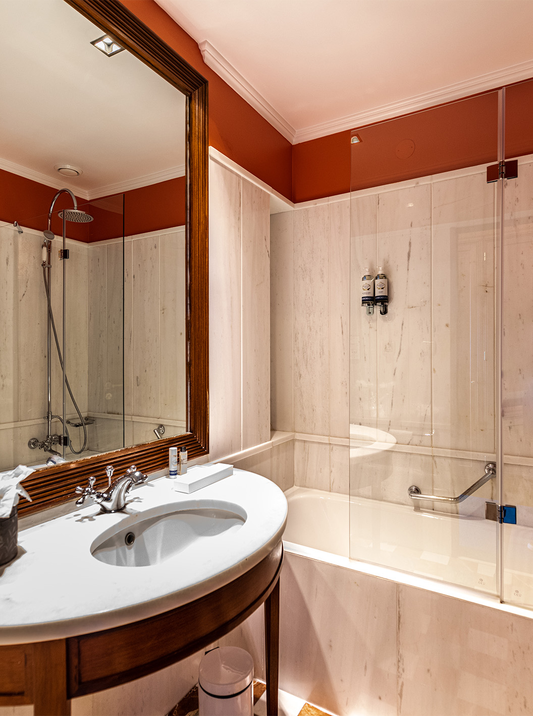 The Deluxe Garden room at Pestana Palace Lisbon features a bathroom with a bathtub, a marble and wood sink, and a mirror