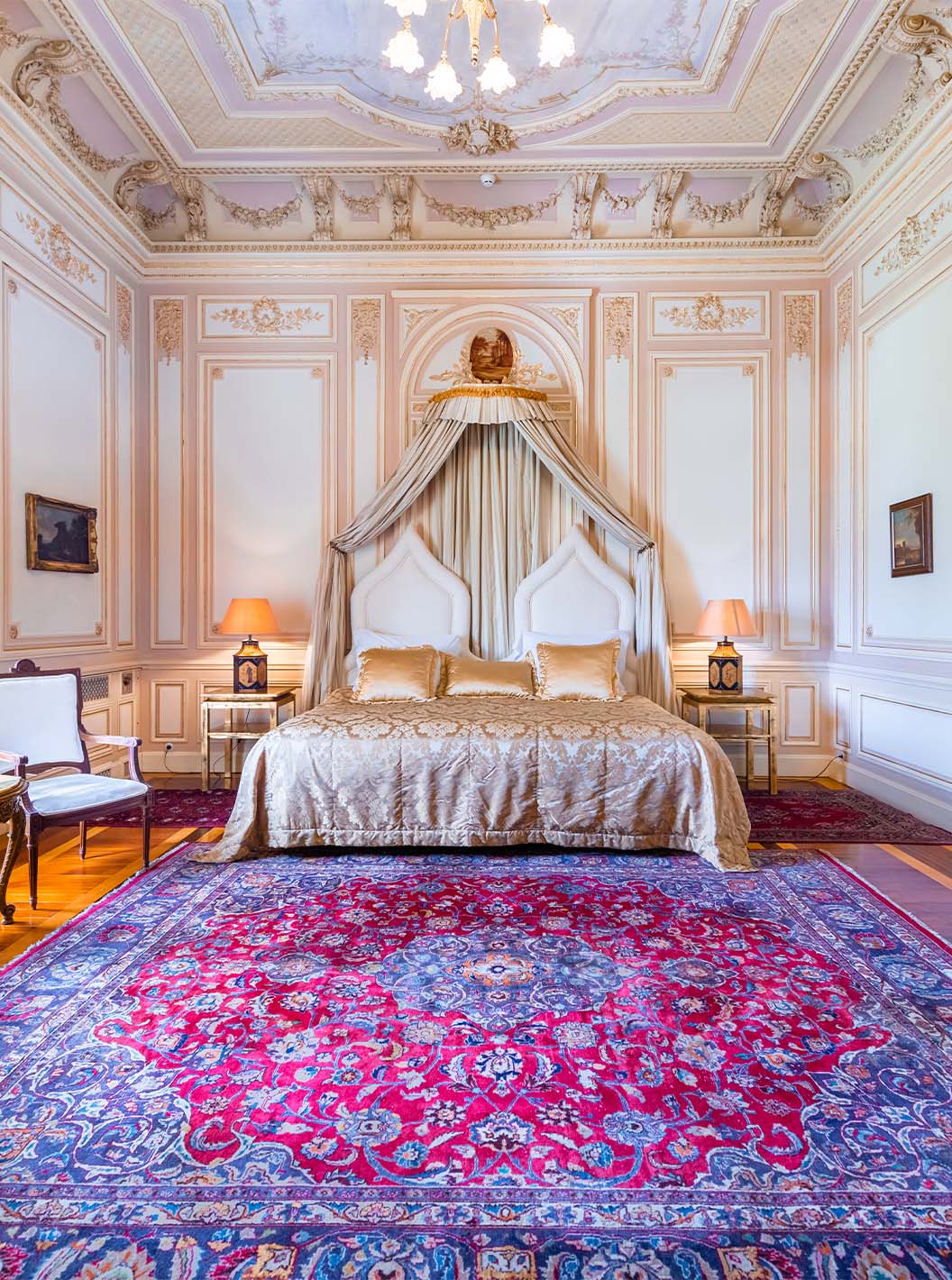 The Suite D. Carlos do Pestana Palace Lisboa has a luxurious room with a double bed and ceiling with ornate details