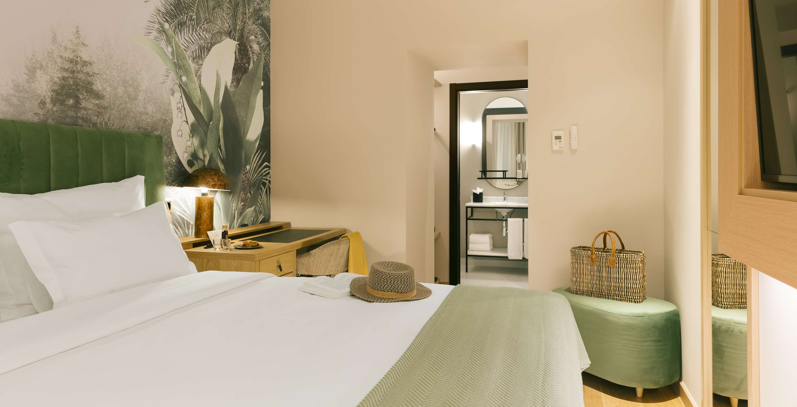 The Comfort Interior of Pestana Rua Augusta Lisboa has a double bed with a green headboard and palm wallpaper