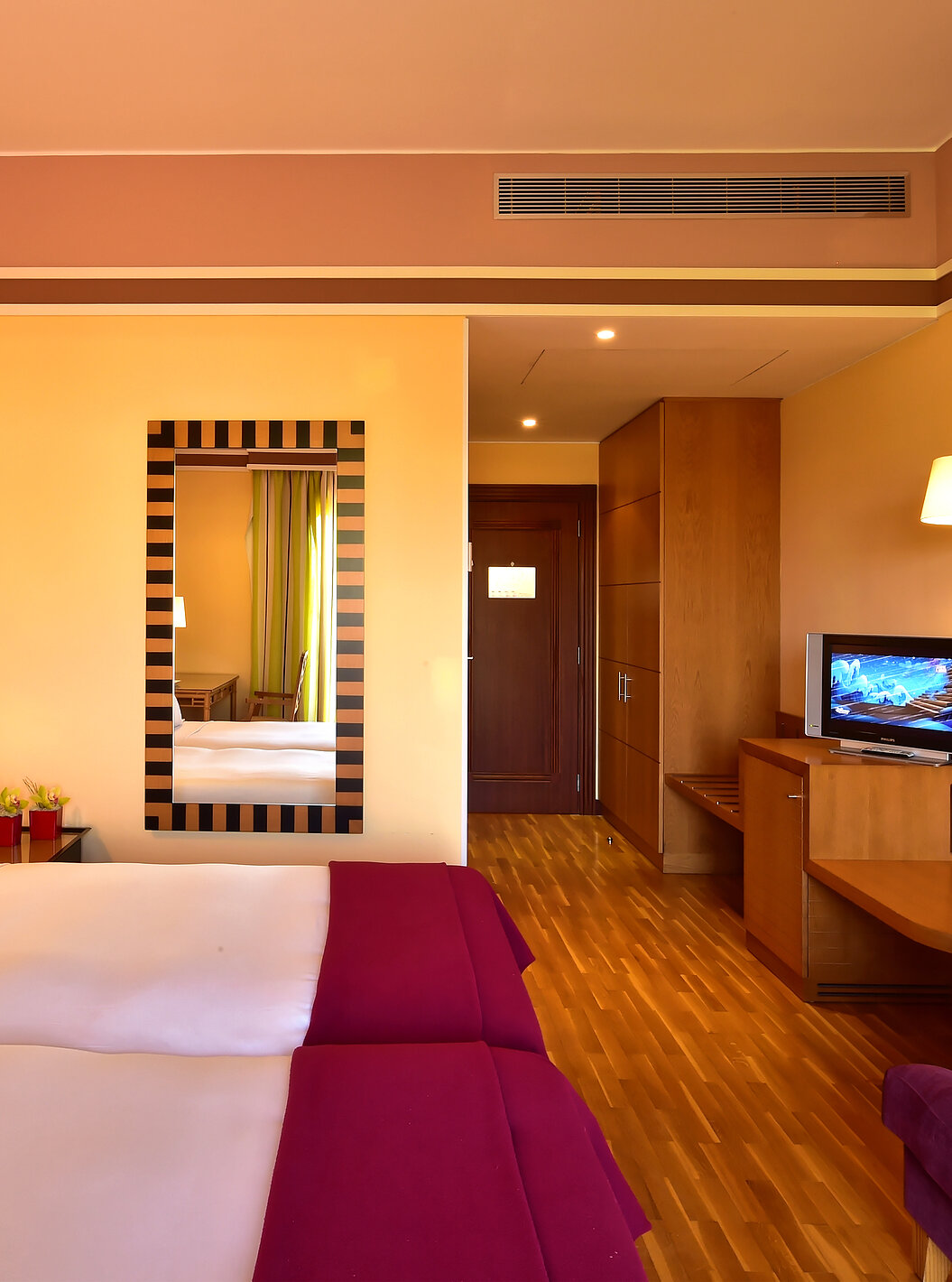 The Classic Double of Pestana Sintra Golf has two beds, a mirror on the wall, and a unit with a small television