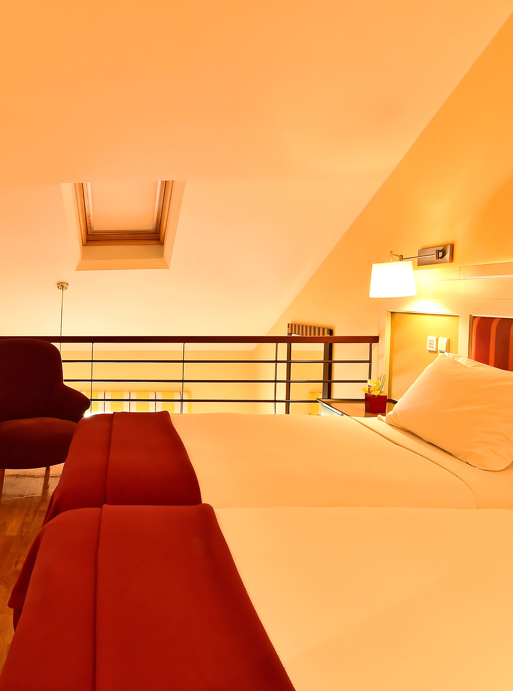The Family Mezzanine Suite of Pestana Sintra Golf has a mezzanine with two beds, a chair, a picture, and a table