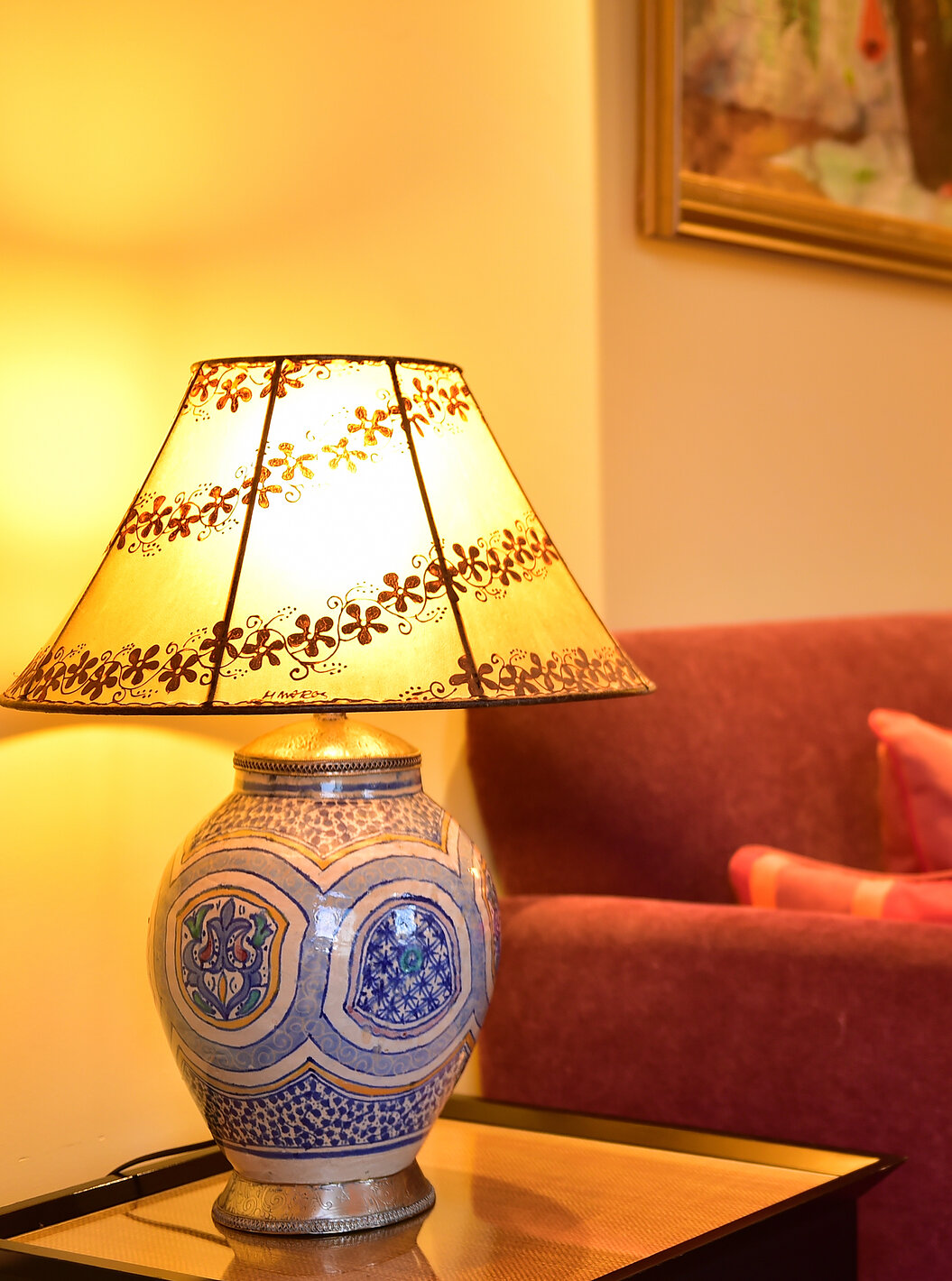 The Superior Suite of Pestana Sintra Golf has a two-seater sofa in red tone and two tables with lamps