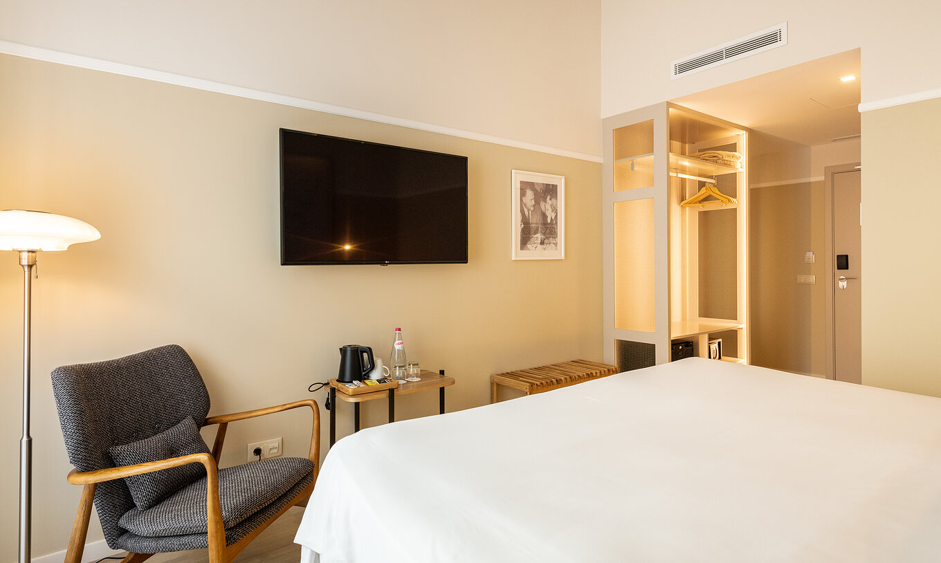 The Comfort room at Pestana Fisherman Village includes a wall-mounted television facing the bed and a wardrobe without doors